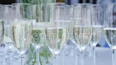 一排装满香槟的酒杯排成一排，准备上桌